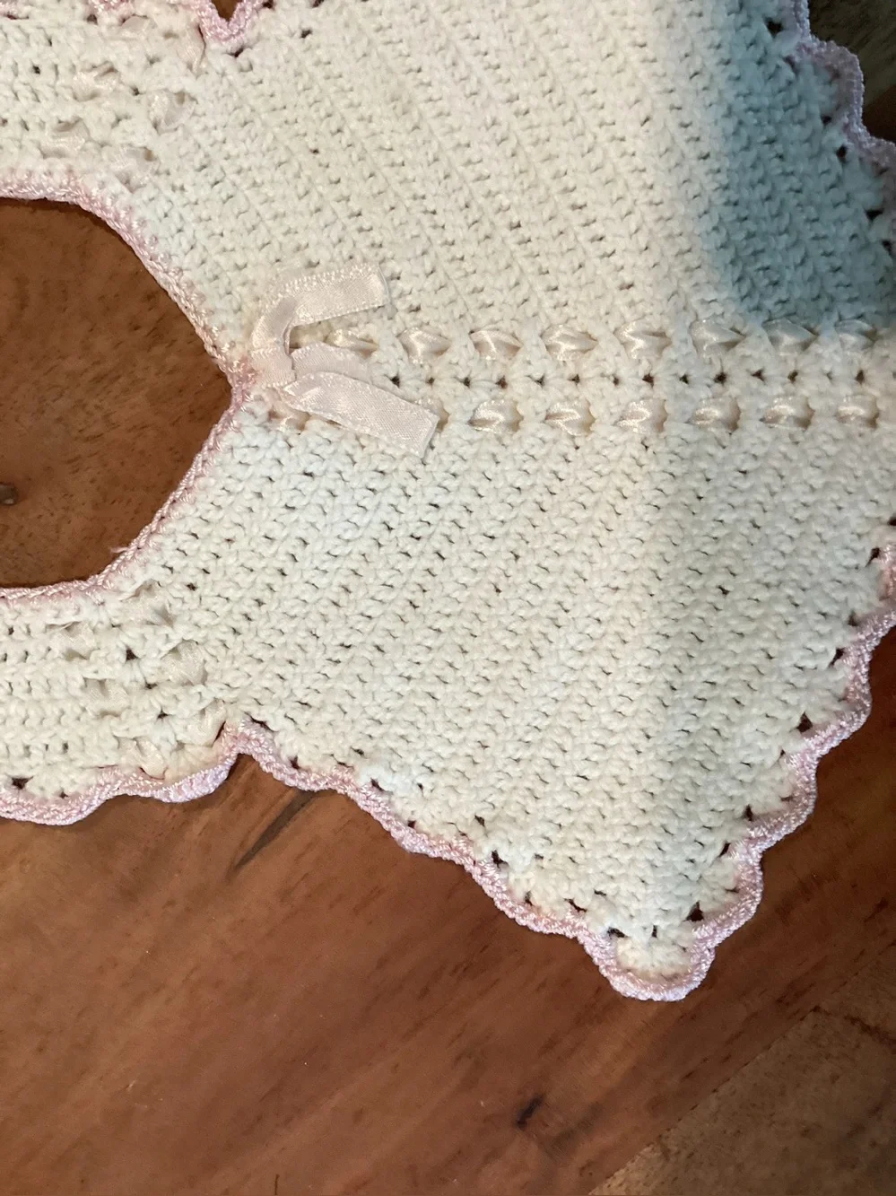 Vintage hand-made crocheted baby bib with pink scalloped lace look trim. 1950s